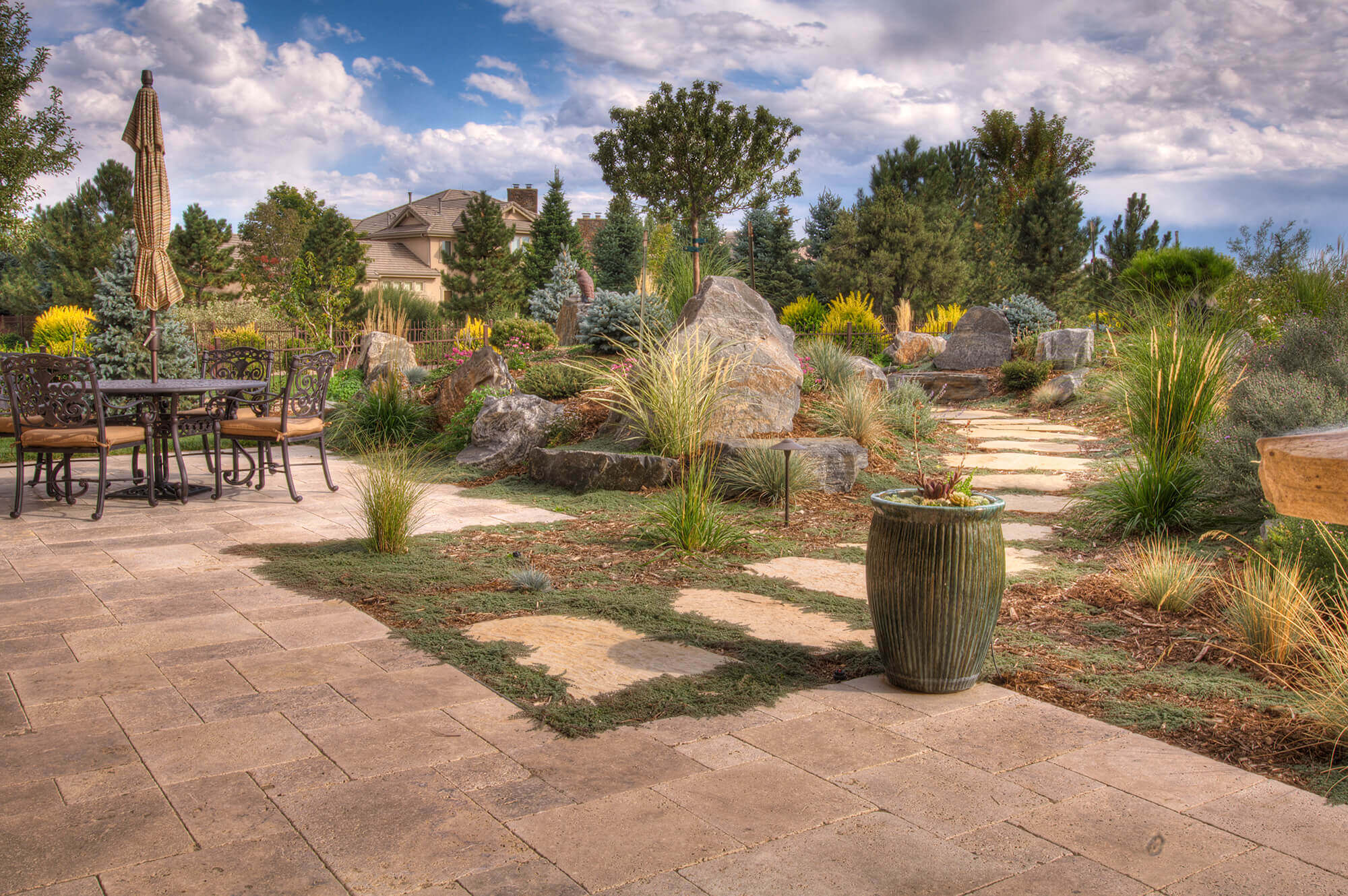 Pathway along with some chairs, table, plants and trees