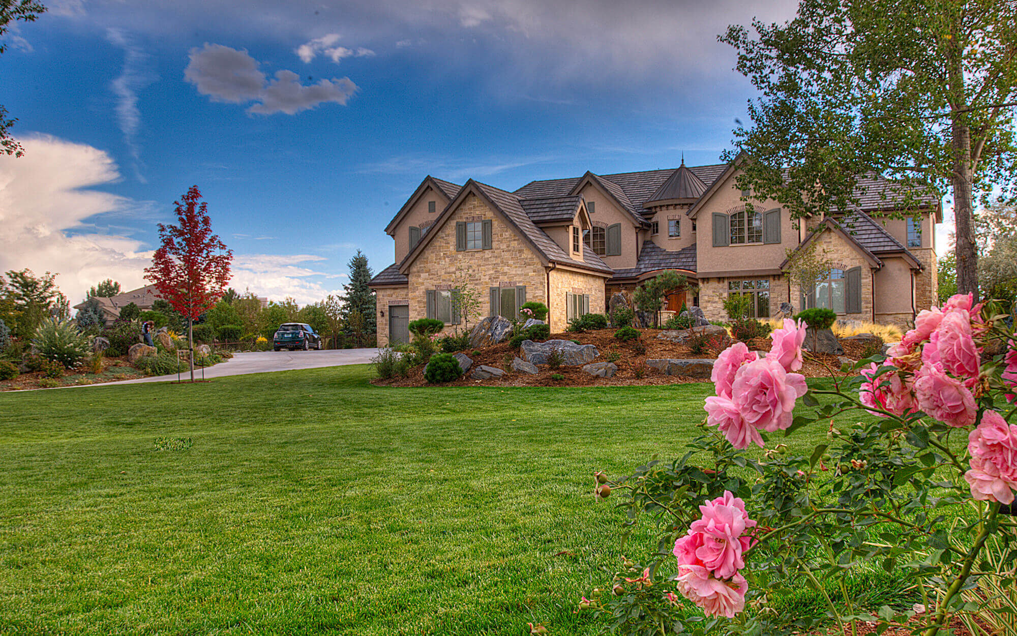 Front view of the house from grass field with beautiful pink roses
