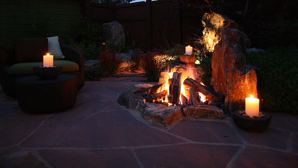 Backyard with sofa, large candles and fire pit