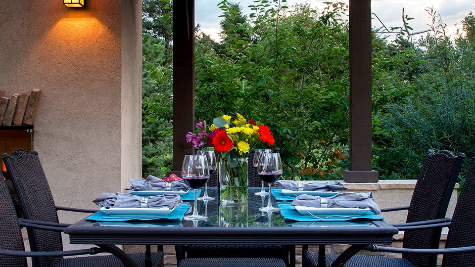 Dining table with wine glass filled with wine and flower vase on it