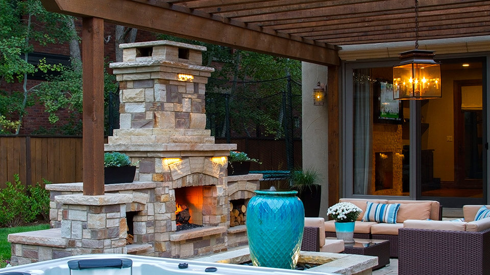 Outdoor chimney by the sitting area along with chairs and sofa in the backyard