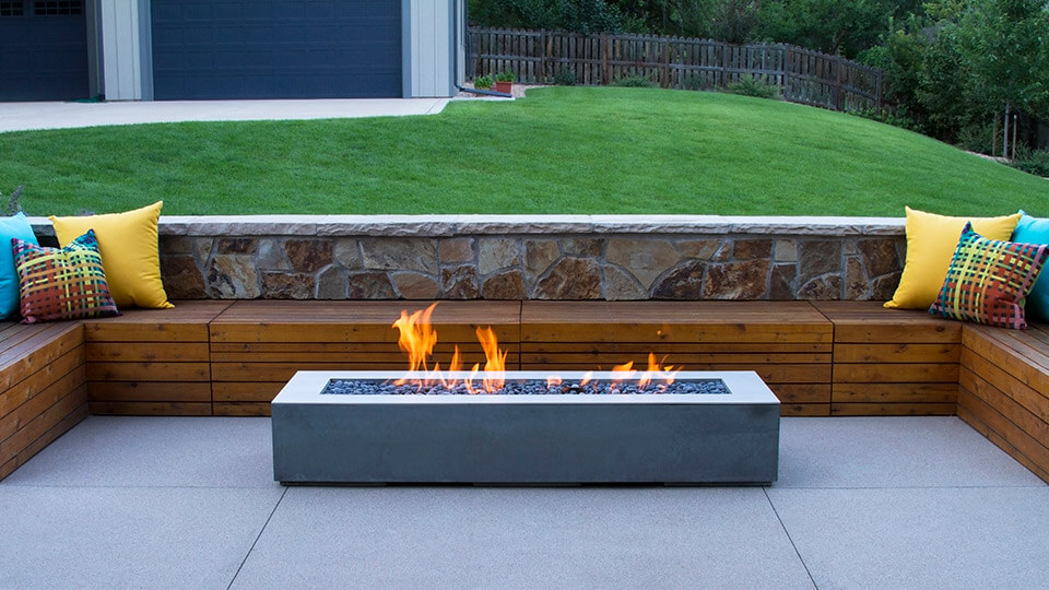 Wooden sofa along with fire pit in the backyard