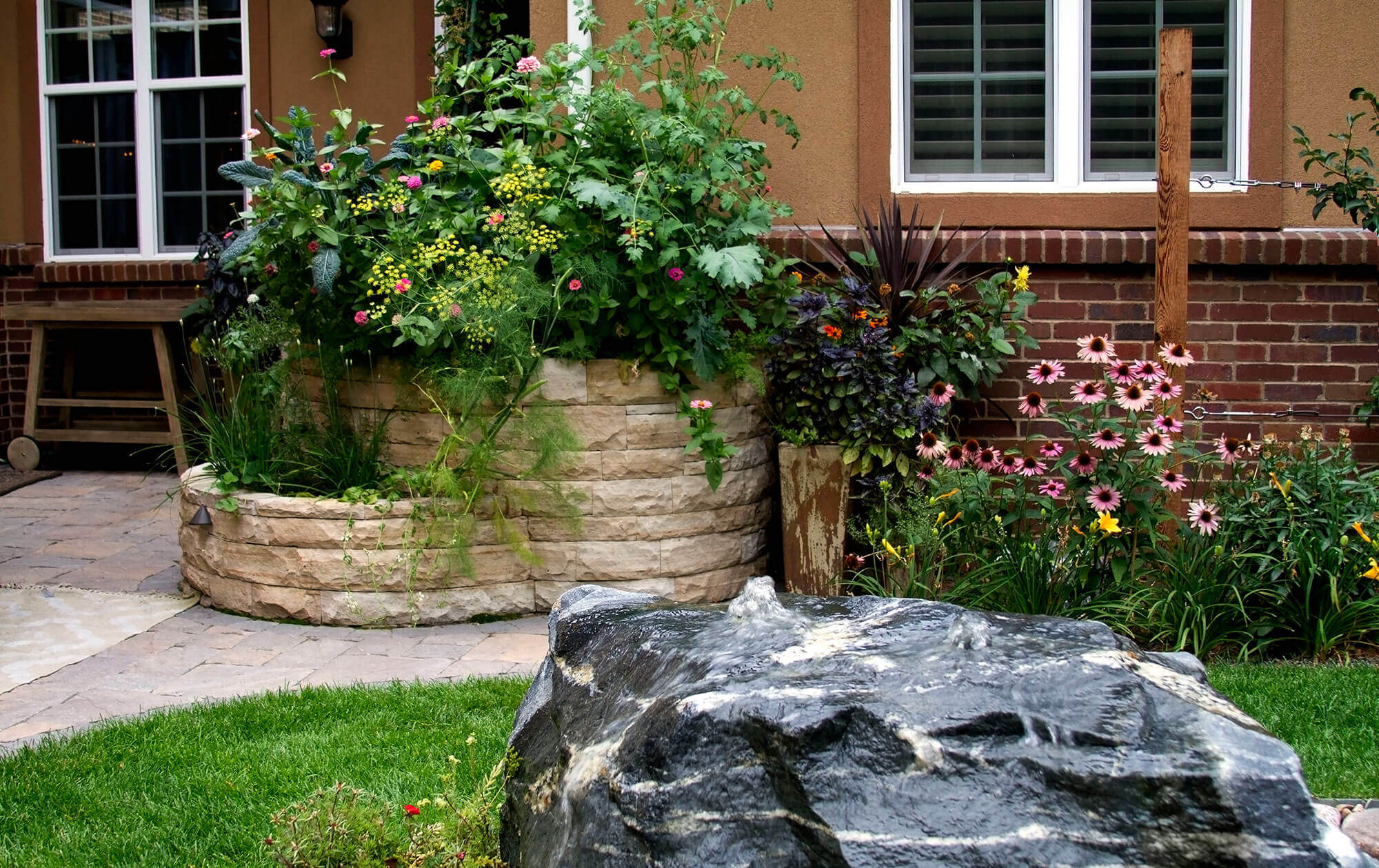 Stone planter filled with flower plants in the backyard