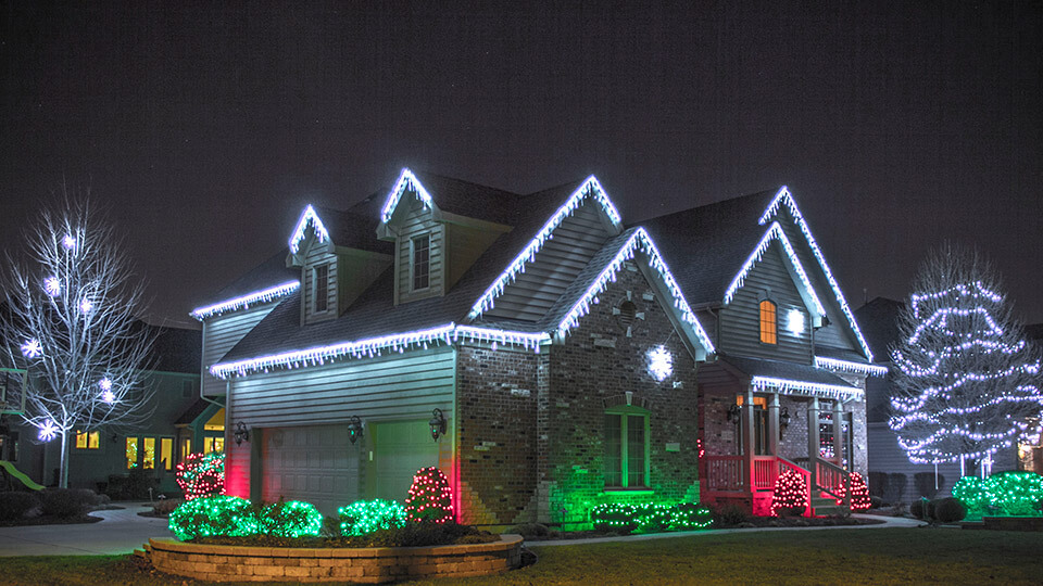 A House, trees and plants are fully decorated with colourful lighting for christmas and new year eve