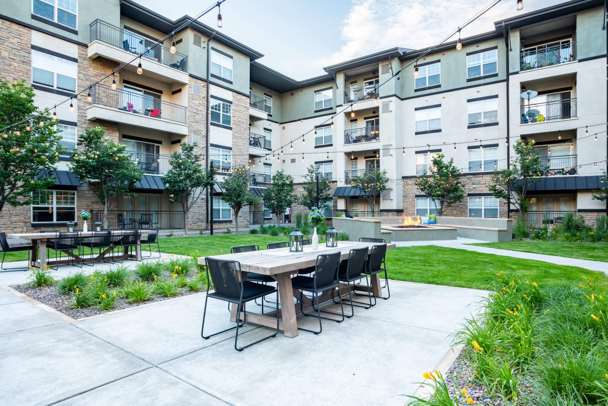 Chairs, tables and firepit setup inside garden area of gated community of flats