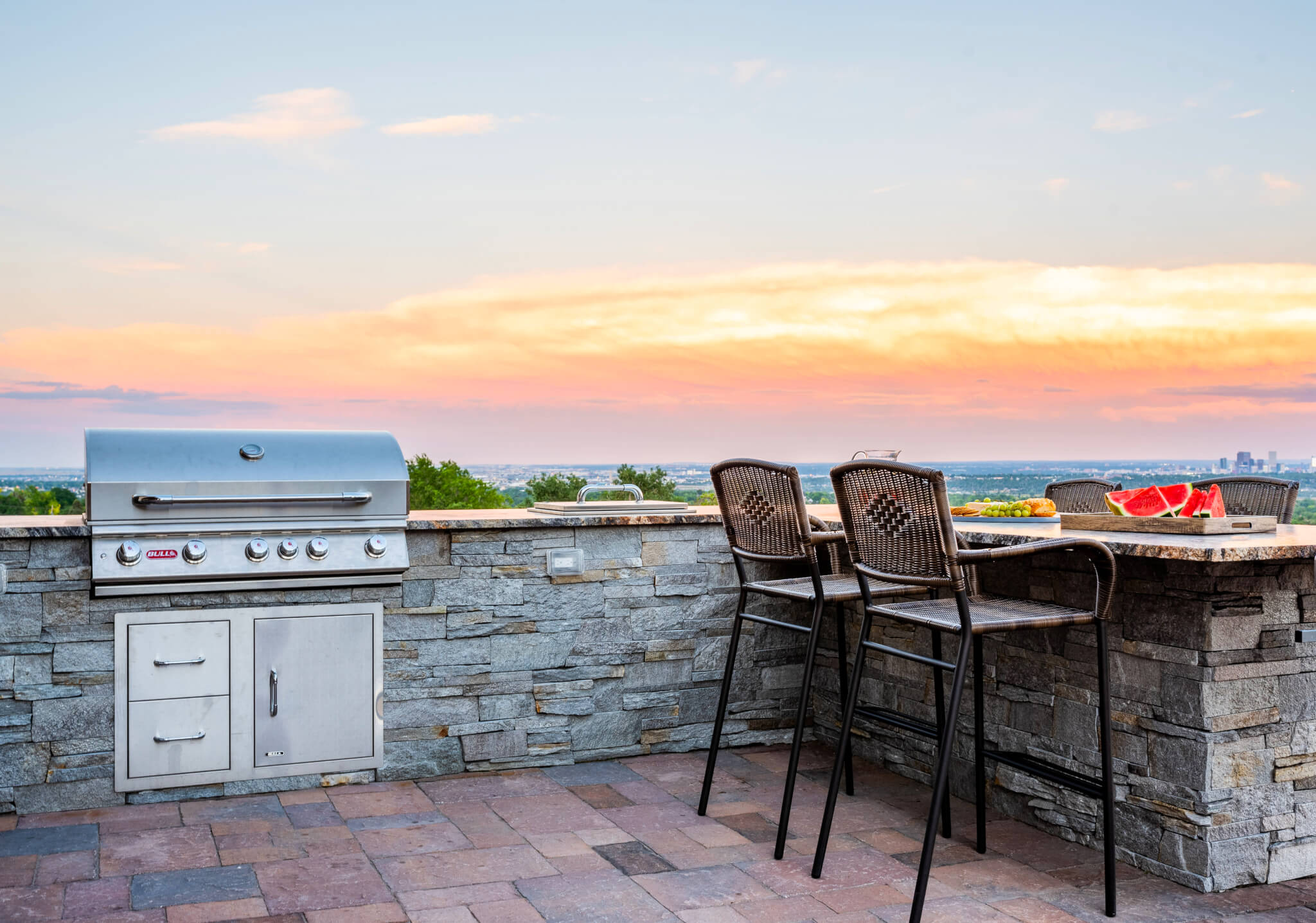 Open kitchen in garden area with some chairs and rock table