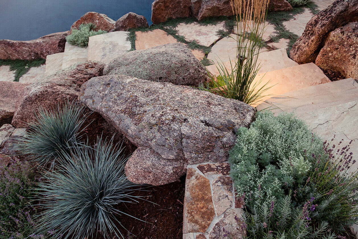 Pathway made of rocks leading uphill surrounded by plants and trees