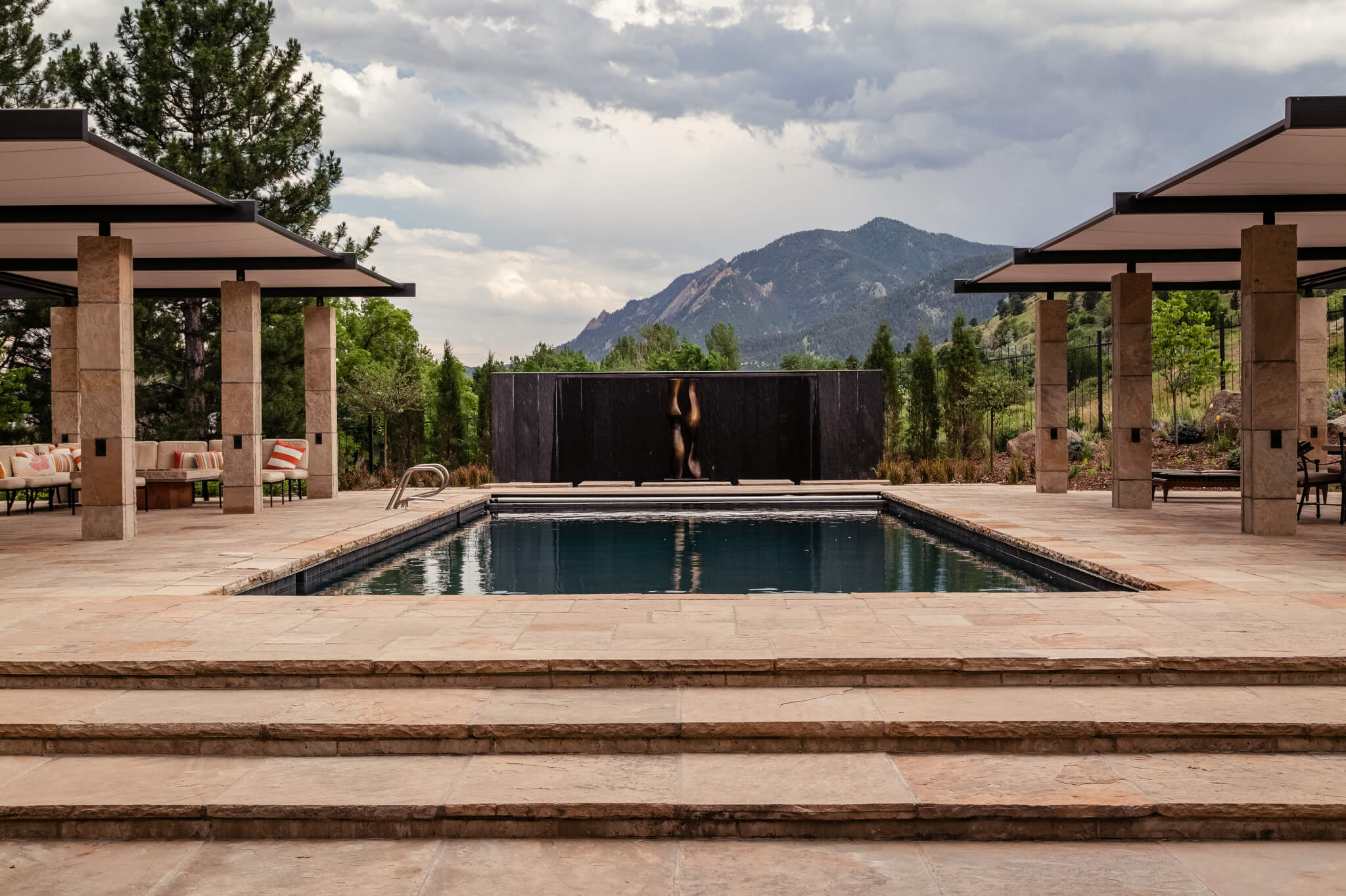 Pool area filled with sofas, resting chairs, dining chairs and a table