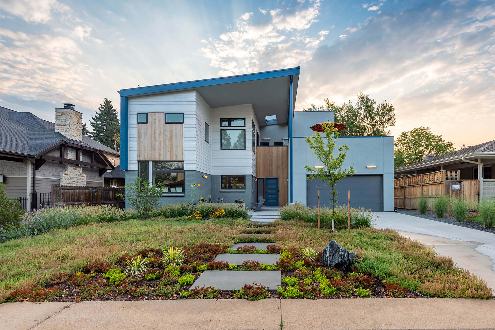 View of a blue colored house and pathway leading to the front entrance