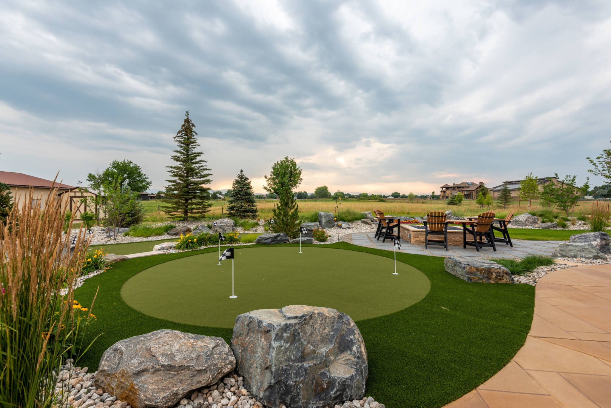 Miniature golf course with fire pit on the side along with chairs