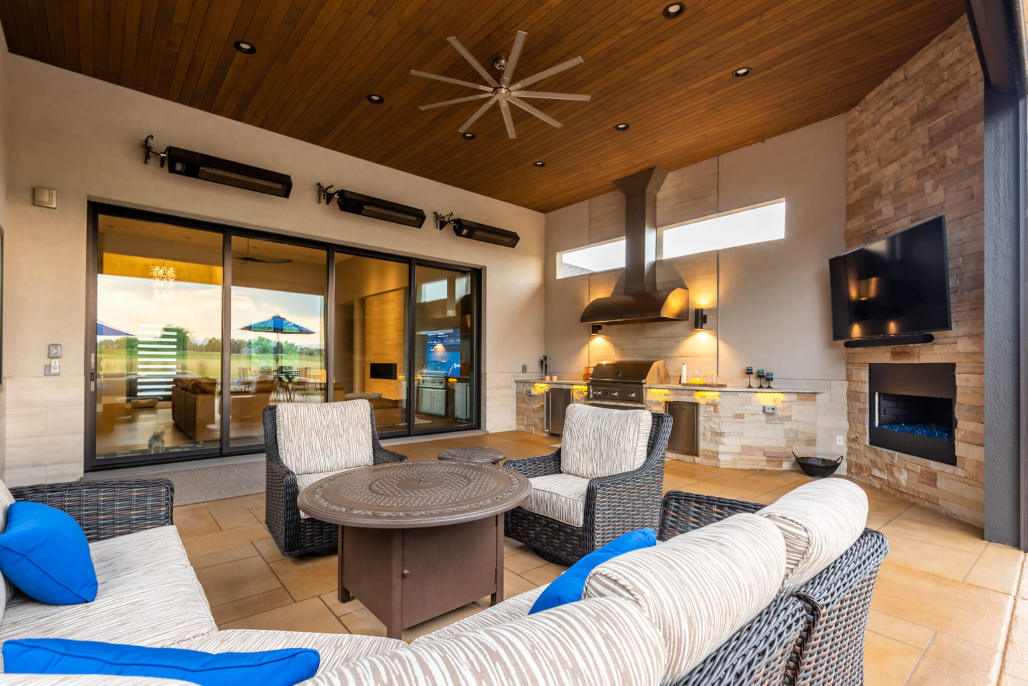 Outside kitchen with chairs, table, and sofas