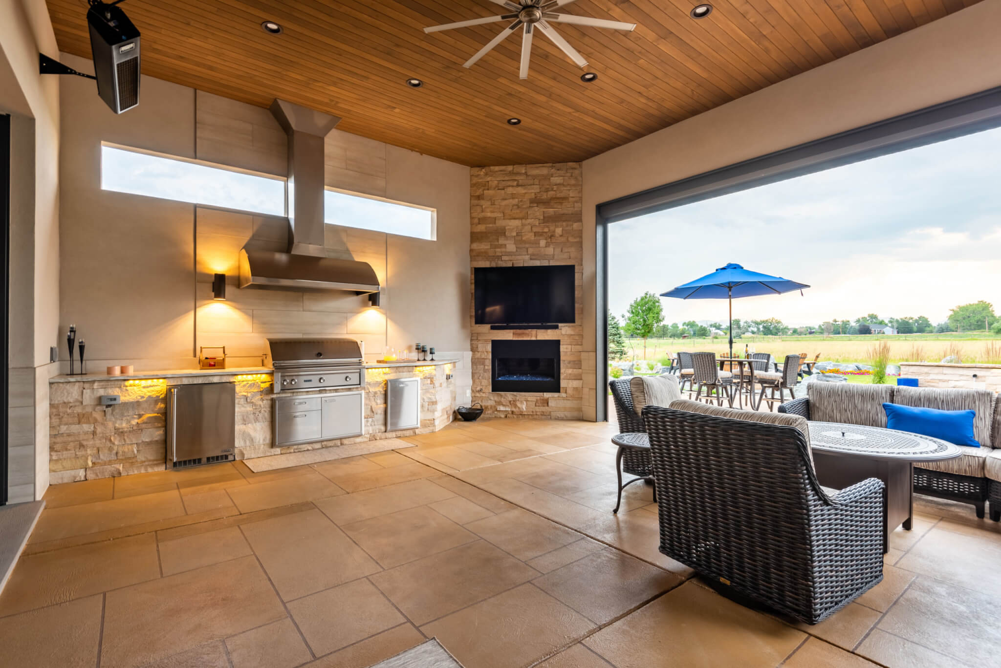 Outside view from open kitchen along with Television, chairs, table and sofas