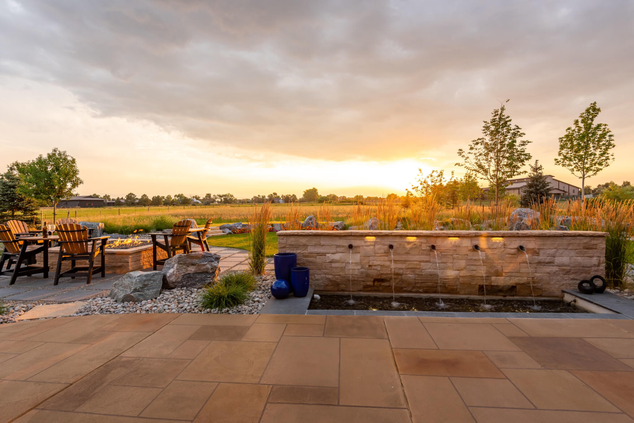 Water fountain setup in backyard along with chairs around the fire pit