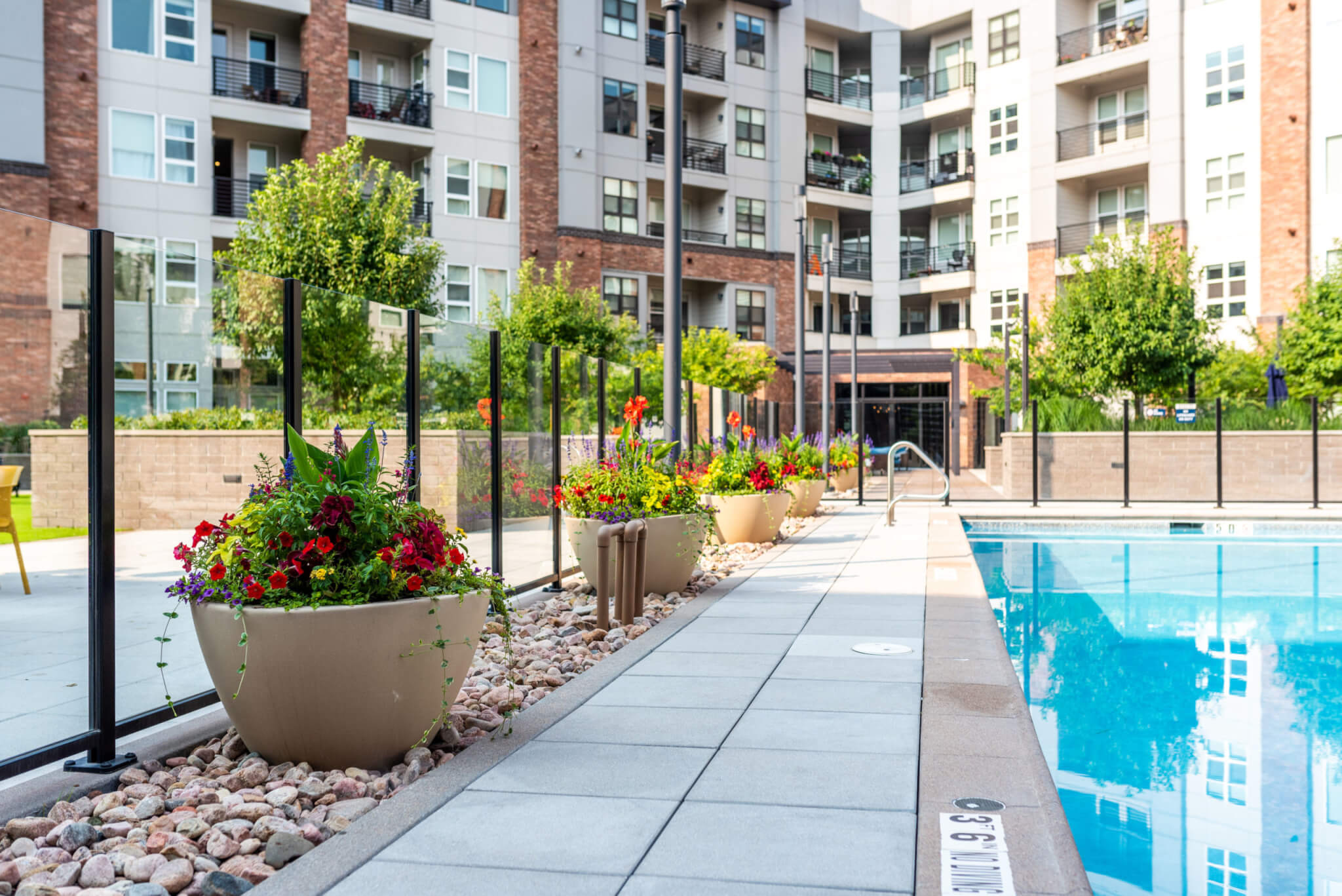 Pool area filled with big flower pots with plants and flowers