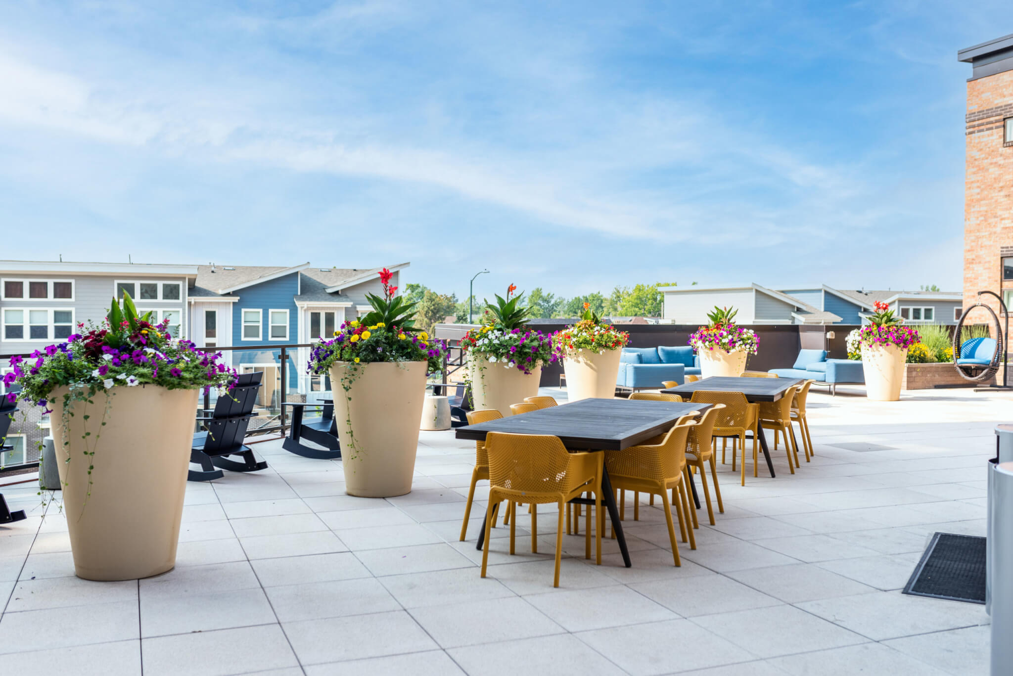 Terrace garden area filled with dining table, chairs and long flower pots