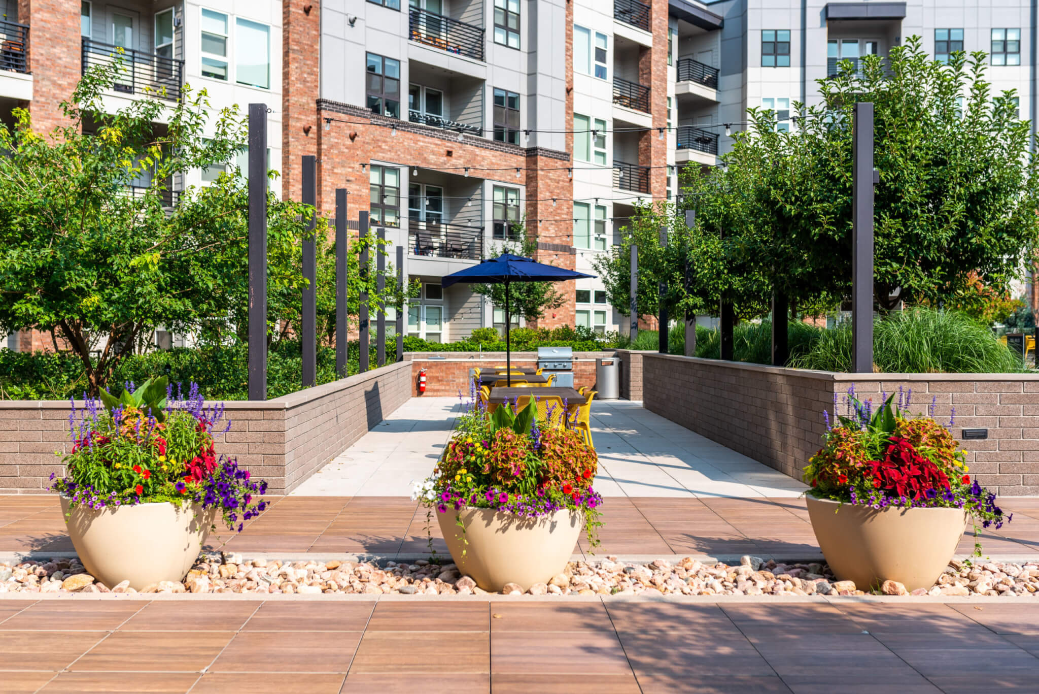 Lawn area filled with dining table, chairs and big flower pots