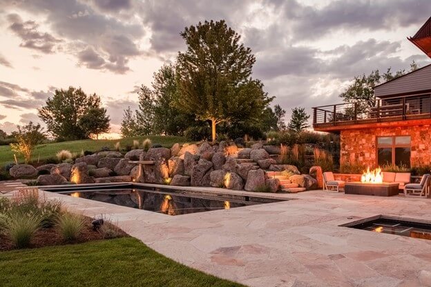 Pool Surrounded by Boulders with Expansive Stone Pool Deck