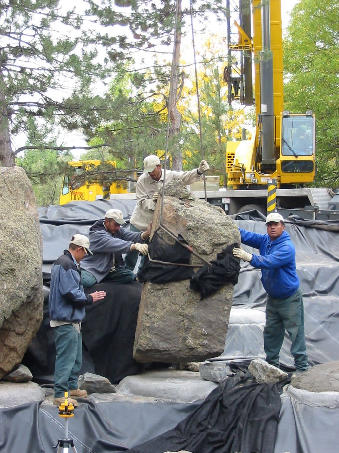 Landscape Professionals Standing in front of Boulder