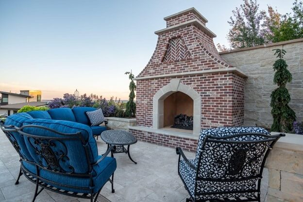 Outdoor Fireplace Surrounded by Blue Chairs