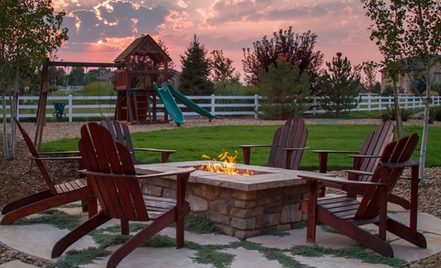 Fire Feature Table Surrounded by Chairs Looking Out Into a Playground