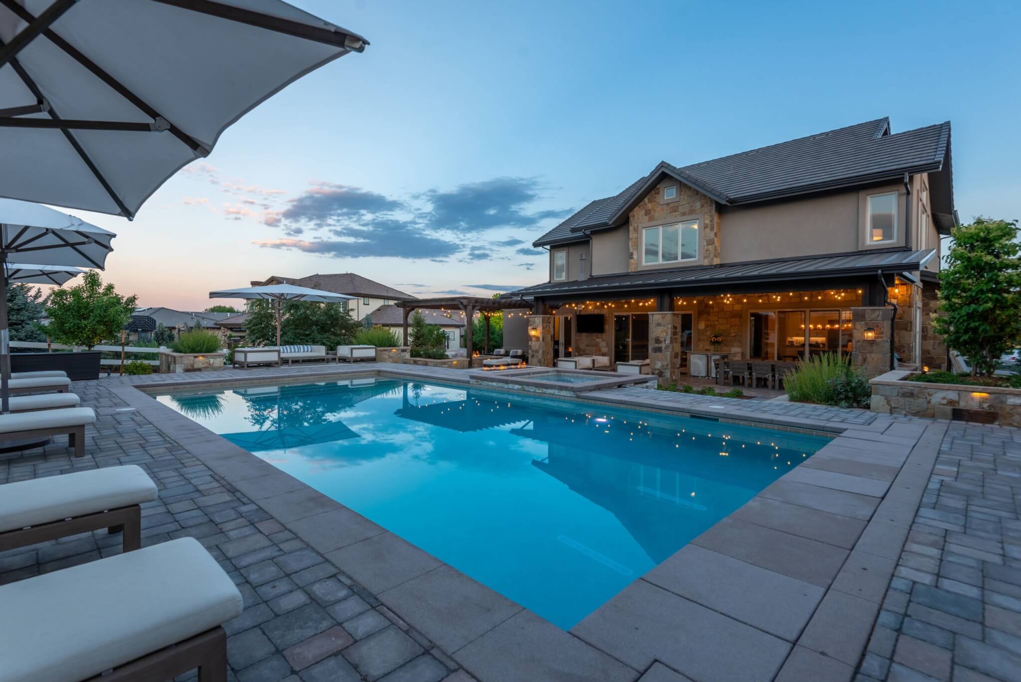 Swimming pool in front of the house with sofas and relaxing chairs