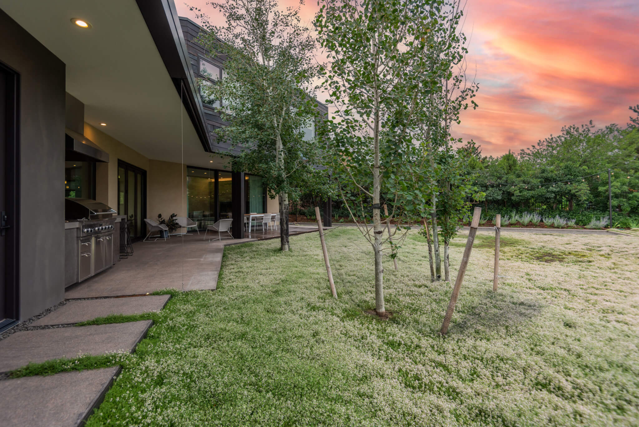 outdoor kitchen with sitting area and a lawn