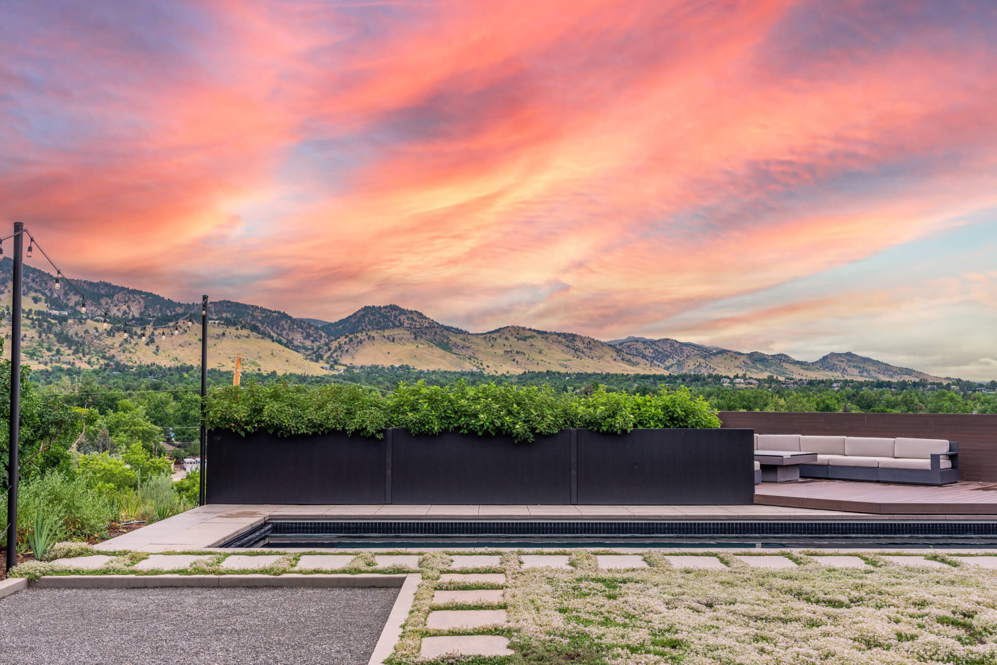 modern xeriscape and pool with concrete pavers, pool, and modern patio furniture. Taken at sunset in Boulder Colorado