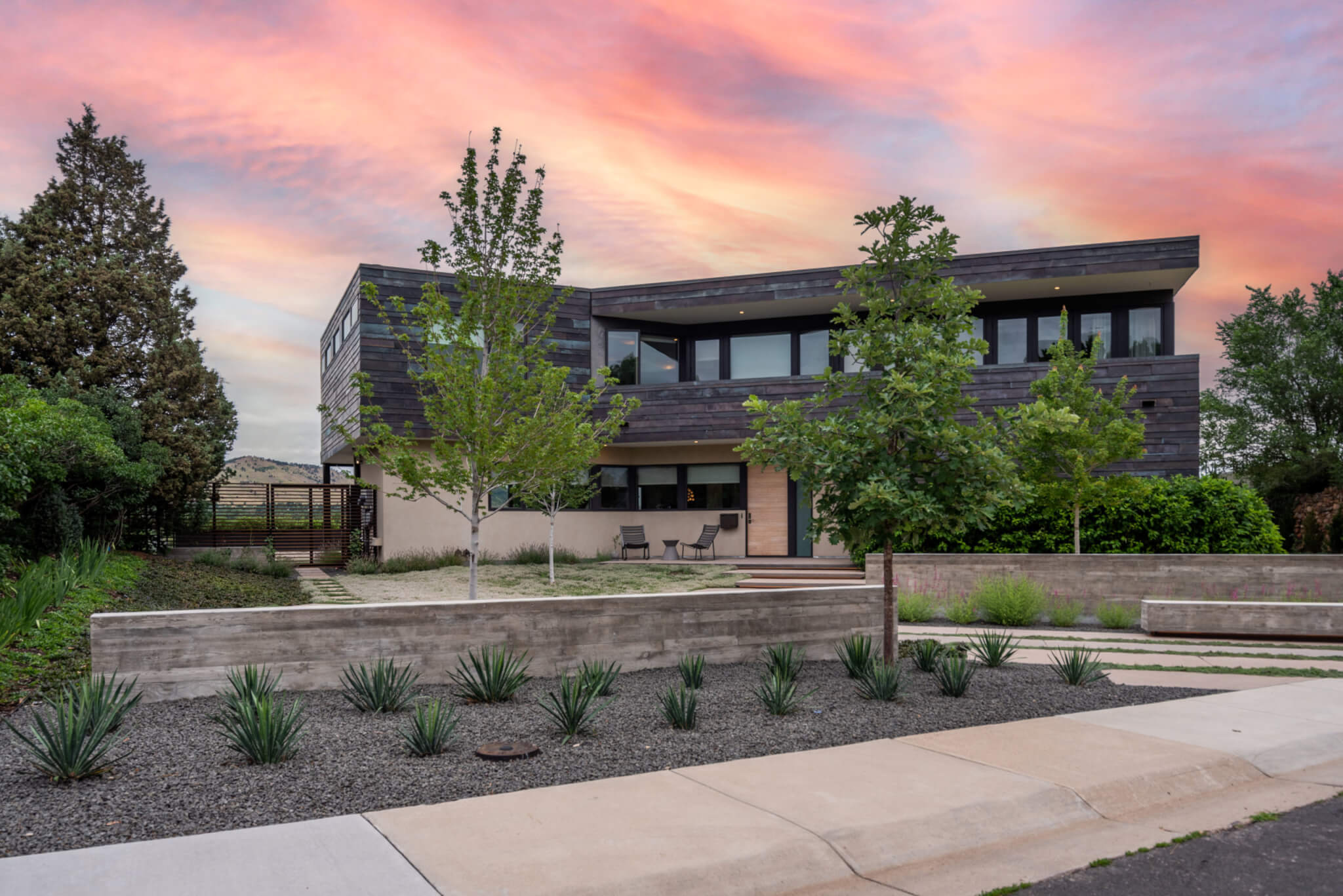 Front view of a house with sunset, plants and trees