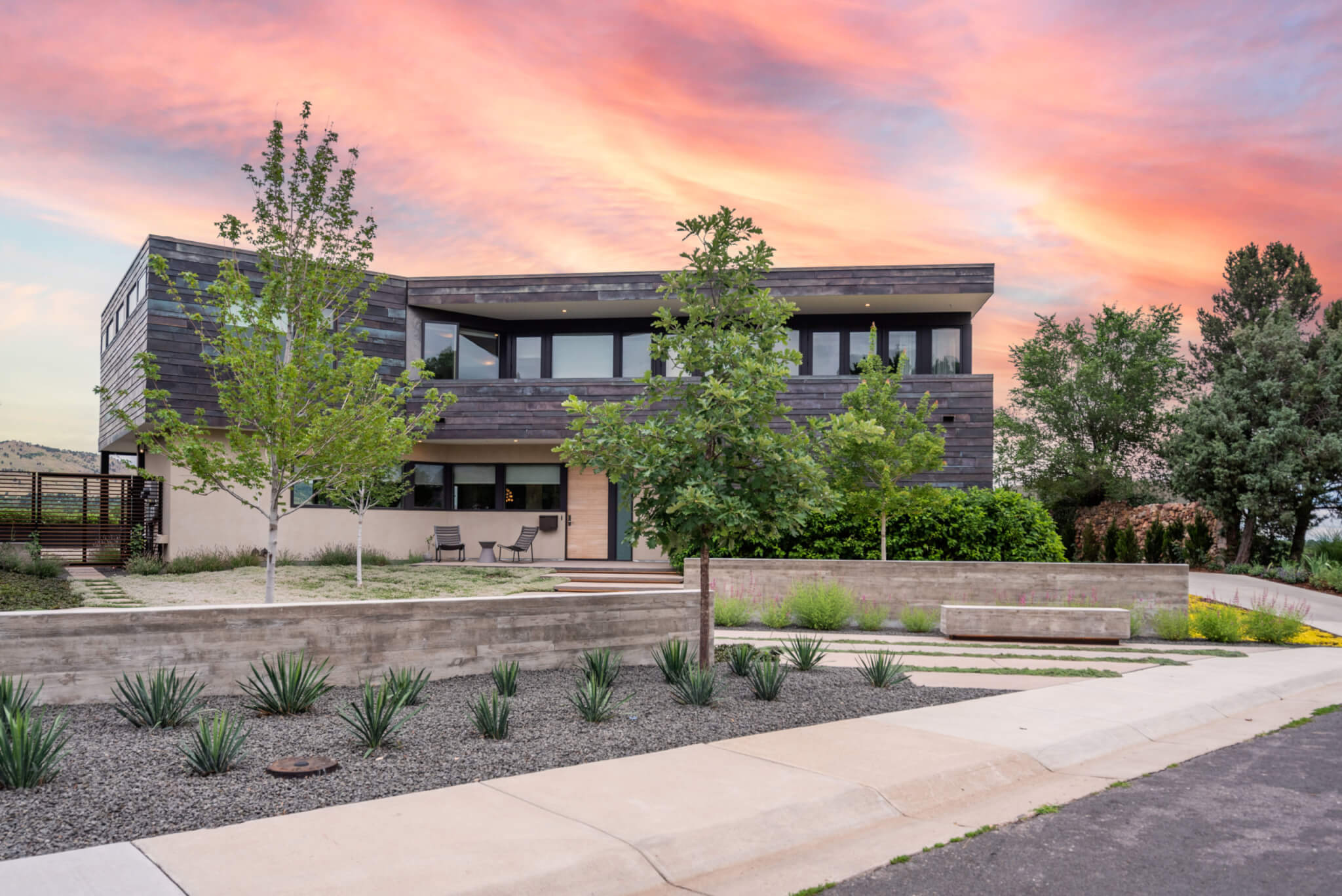 Front view of a house with sunset, plants and trees