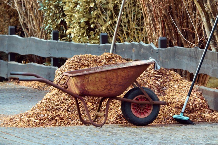 Mound of mulch next to a wheelbarrow