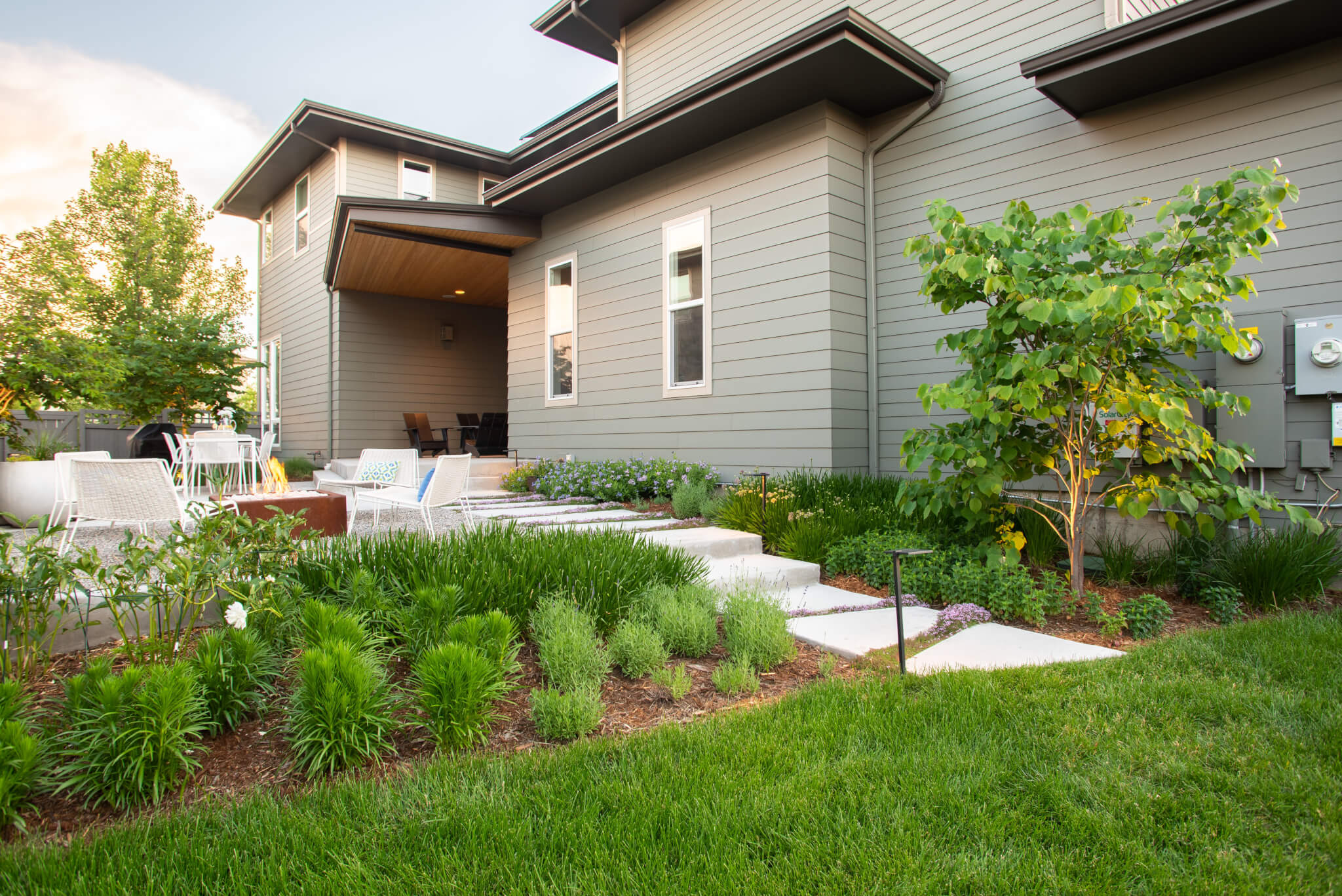 Backyard along with fire pit, chairs, dining table, grass plants and trees