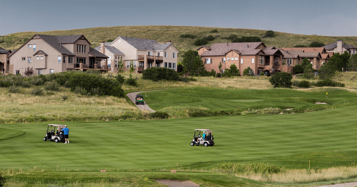 castle rock grass lawn golf course during the day with large houses in the background